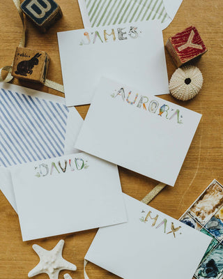 Flatlay photo of personalized Animal Stationery by The Letter Nest in name Aurora, David, Max, and James, spelled in animal letters