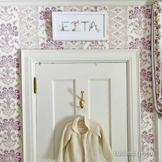 Woodland Name Print hanging in nursery with decorative wallpaper with name "Etta" in a white frame